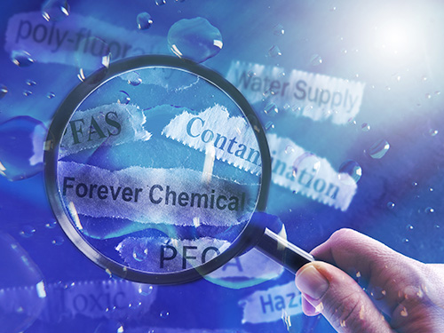 Magnifier over several strip of paper with PFAS terminology on it.